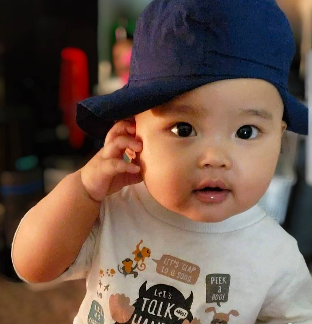 Julie is registered to the contest to win money with this photo: baby, baby_toddler_clothing, cap, cheek, child, clothing, eye, eyelash, finger, gesture, happy, hat, headgear, headwear, lip, person, photograph, sleeve, snapshot, t_shirt