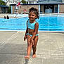 Dariahynis is registered to the contest to win money with this photo: child, swimsuit, poolside, smiling, barefoot, curly_hair, outdoor, summer, water, recreation, concrete, swimming_pool, lifeguard_chair, daylight, fun, innocence, person, happy, walking, blue