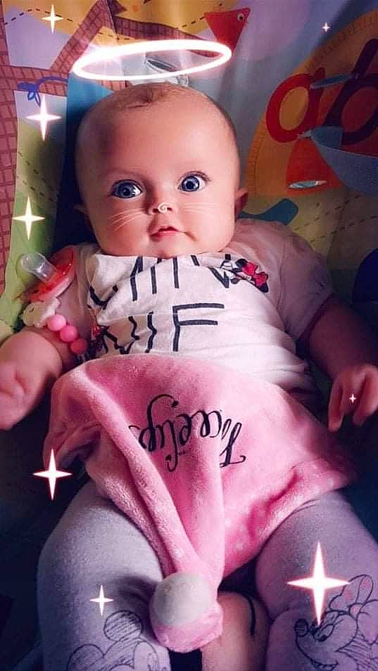 Maelys participe au concours pour gagner de l'argent avec cette photo : baby, baby_products, baby_toddler_clothing, cheek, child, doll, eye, eyelash, happy, head, lip, magenta, person, pink, sitting, skin, sleeve, thigh, toddler, toy