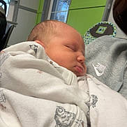 Bentley joined the competition — help win amazing prizes! baby, blanket, sleeping, indoor, person, clothing, nike, newborn, face, head, window, green_wall, sweatshirt, child, peaceful, wrapped, soft, infant, portrait, resting