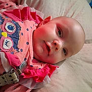 Ariel is registered to the contest to win money with this photo: baby, infant, cute, pink_clothing, owl_design, lying_down, rosy_cheeks, soft_bedding, child, portrait, indoors, close_up, person, young_child, sleepwear, cozy, adorable, head, face, expression
