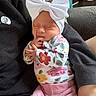 Evelynn joined the competition — help win amazing prizes! baby, infant, sleeping, bow, headband, floral_clothing, pink_pants, person, arms, couch, indoor, soft_lighting, peaceful, cute, newborn, hand, face, relaxing, resting, child