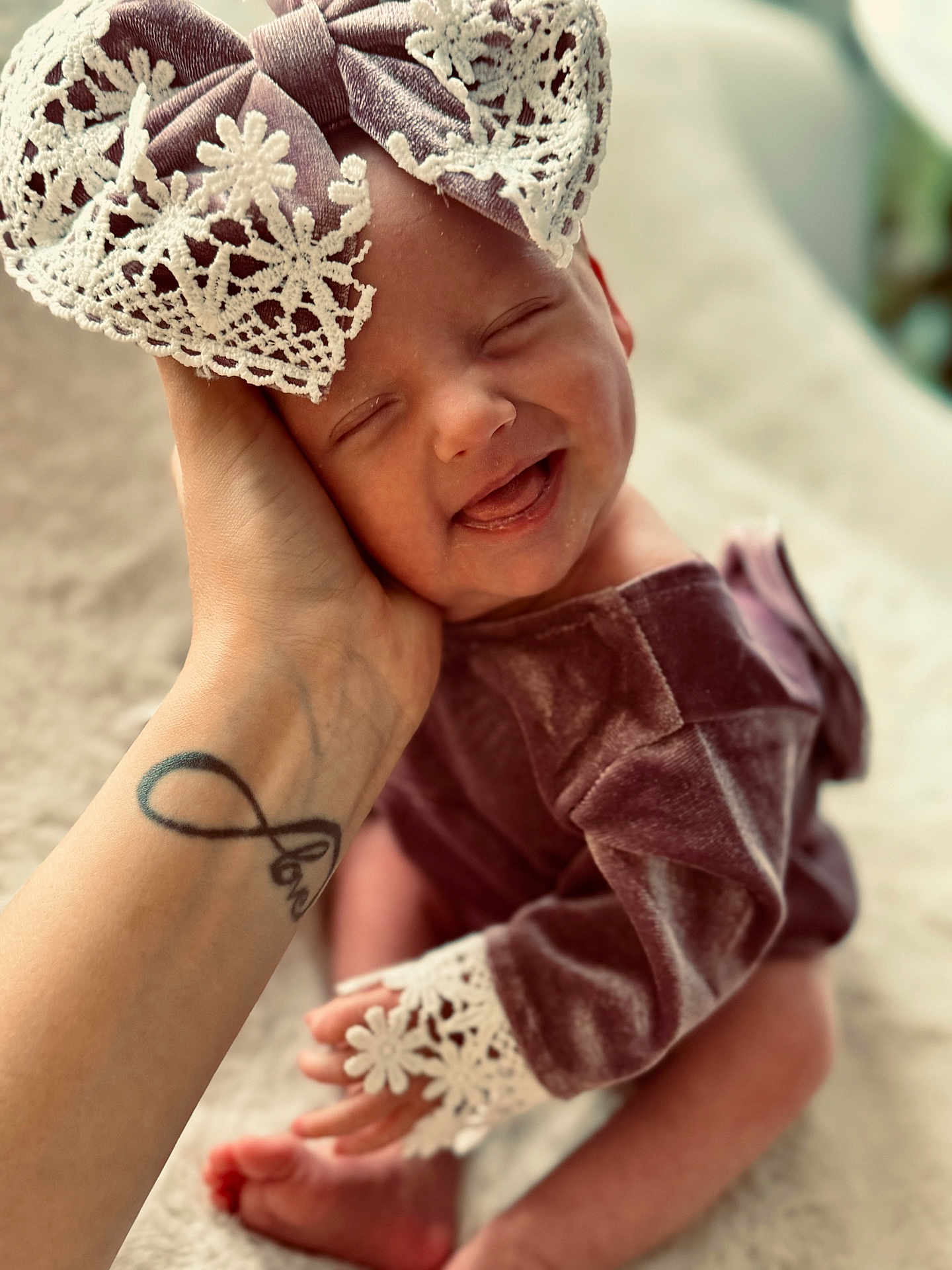 Maïly participe au concours pour gagner de l'argent avec cette photo : baby, newborn, smiling, hand, tattoo, lace, bow, headband, velvet, clothing, infant, cute, happy, tongue_out, cozy, blanket, soft, portrait, skin, person