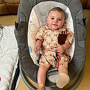 Kenzo participe au concours pour gagner de l'argent avec cette photo : baby, baby_rocker, child, clothing, comfortable, cushion, cute, fabric, face, footwear, furniture, happy, home, indoor, infant, pattern, person, seat, smile, toy