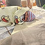 Riker is registered to the contest to win money with this photo: baby, blanket, bed, pacifier, hat, mustache, striped_hat, winnie_the_pooh, person, indoor, cute, child, lying_down, adult_arm, fabric, plush, smile, sleepwear, funny, cozy