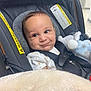 Bryan is registered to the contest to win money with this photo: baby, car_seat, infant, smile, soft_toy, blanket, seatbelt, clothing, indoors, child, face, person, cute, young_child, head, sitting, expression, safety, happy, toy