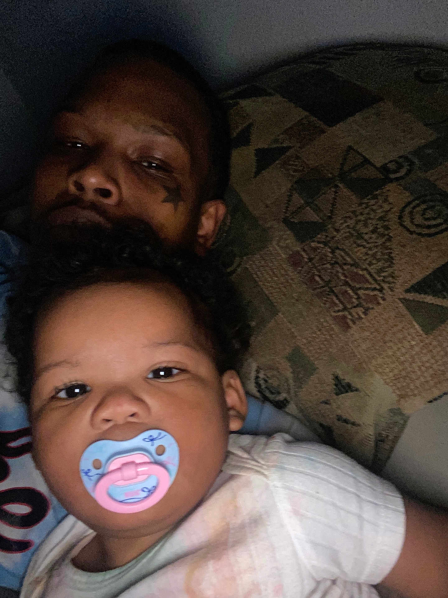 Janaya joined the competition — help win amazing prizes! baby, pacifier, adult, tattoo, face, portrait, curly_hair, indoor, pillow, pattern, closeup, person, sleepy, child, family, candid, casual, relaxed, skin, clothing