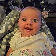 Ellee joined the competition — help win amazing prizes! baby, infant, smiling, blanket, floral, fleece, indoor, living_room, child, person, cute, happy, seated, young_child, cozy, clothing, face, head, eyes, mouth