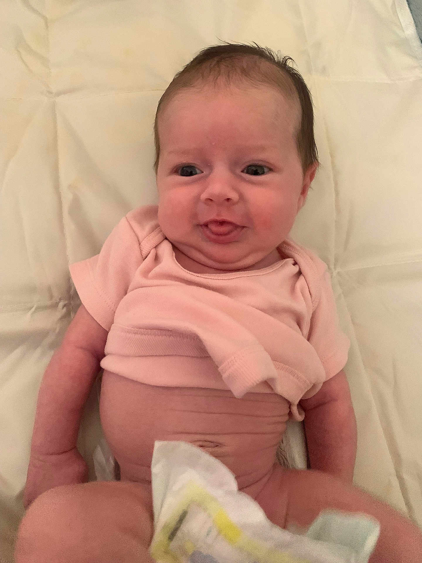 Everleigh-Marie is registered to the contest to win money with this photo: baby, infant, diaper, pink_shirt, lying_down, tongue_out, cute, chubby, soft_blanket, skin, arm, head, face, expression, newborn, child, indoors, person, young, smile
