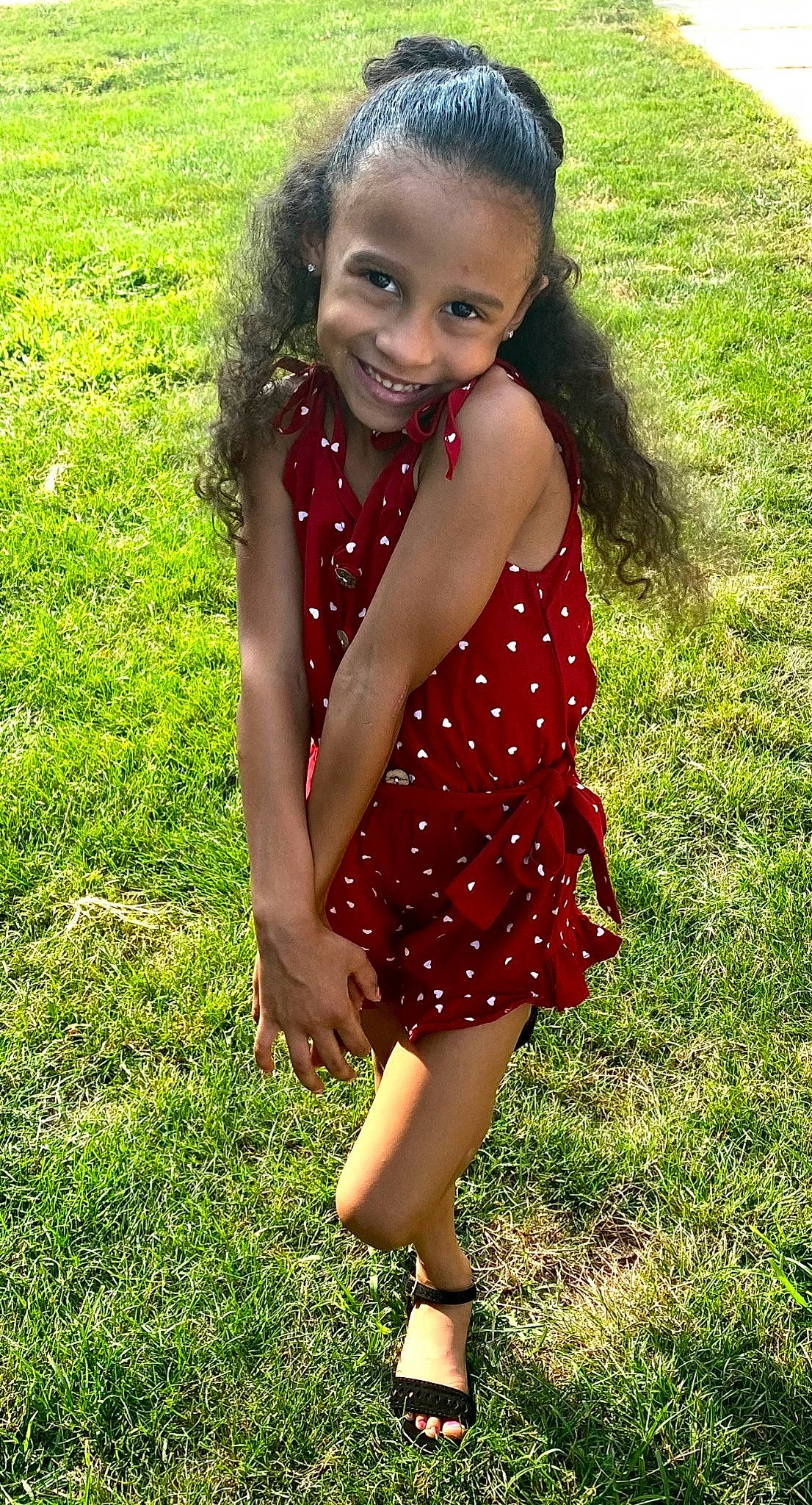 Emma is registered to the contest to win money with this photo: blond, brown_hair, day_dress, fawn, grass, grassland, green, happy, head, joy, long_hair, meadow, one_piece_garment, pattern, people_in_nature, person, plant, smile, thigh, toddler