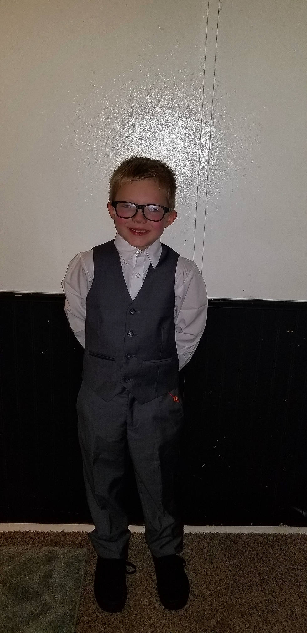 Kilby is registered to the contest to win money with this photo: eyewear, formal_wear, fun, gentleman, glasses, joy, outerwear, person, smile, standing, suit, tuxedo, vision_care
