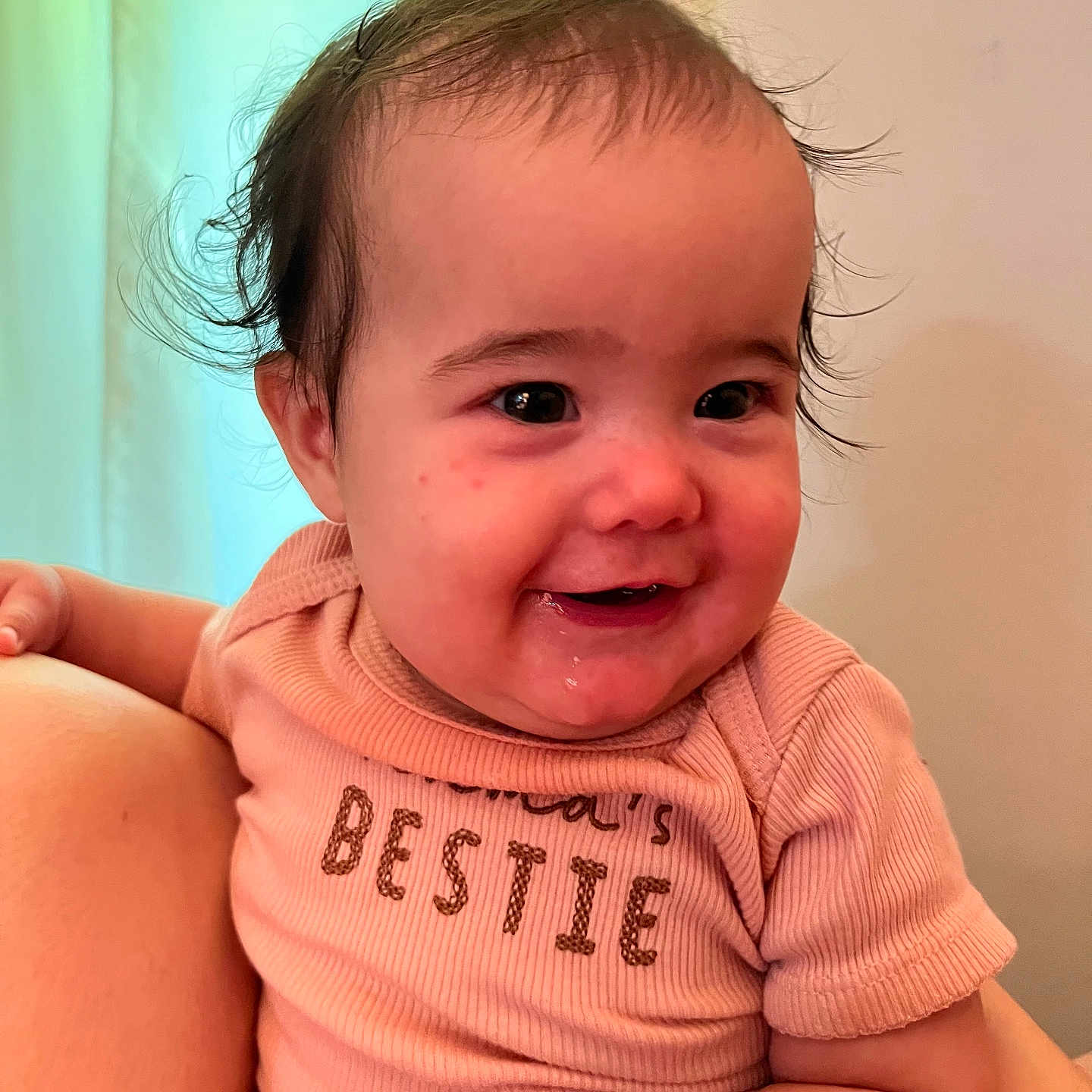 Kehlani is registered to the contest to win money with this photo: arm, baby, child, clothing, cute, expression, face, hair, hand, happy, holding, indoors, infant, person, pink_shirt, portrait, skin, smiling, text_on_clothing, young