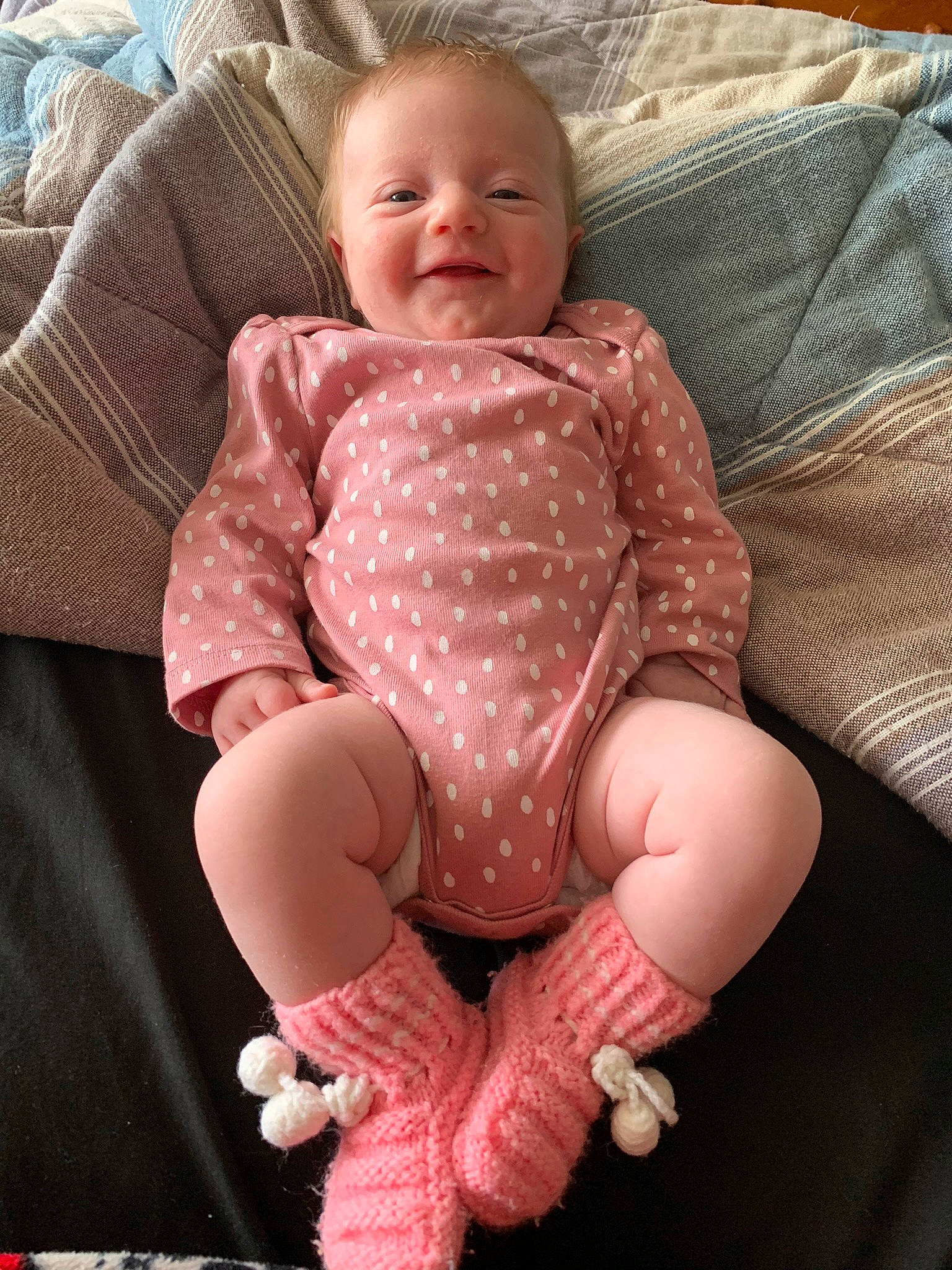 Amber is registered to the contest to win money with this photo: baby, baby_toddler_clothing, cheek, comfort, eye, face, finger, head, human_body, knee, lap, neck, person, pink, skin, sleeve, smile, sock, textile, thigh