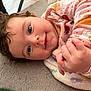 Amaya is registered to the contest to win money with this photo: baby, child, smiling, curly_hair, pink_clothing, blanket, hand, face, blue_eyes, infant, soft_surface, cute, lying_down, indoors, person, closeup, portrait, happy, warm, cozy