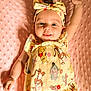 baby, infant, child, smiling, winnie_the_pooh, headband, yellow_clothing, pink_blanket, curly_hair, cute, raising_arm, lying_down, soft_texture, playful, portrait, happy, indoors, closeup, one_person, baby_girl