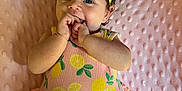 Amaya is registered to the contest to win money with this photo: baby, child, infant, smiling, cute, yellow_bow, curly_hair, pink_blanket, lemon_pattern, onesie, happy, playful, hand_in_mouth, portrait, lying_down, soft_texture, indoors, adorable, young_child, headband