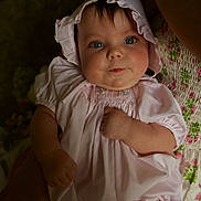 Evangeline is registered to the contest to win money with this photo: baby, child, infant, face, blue_eyes, bonnet, dress, pink, clothing, person, portrait, hand, cute, young, skin, cheeks, sitting, soft_lighting, indoor, holding