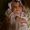 baby, child, infant, face, blue_eyes, bonnet, dress, pink, clothing, person, portrait, hand, cute, young, skin, cheeks, sitting, soft_lighting, indoor, holding