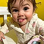 Alaia joined the competition — help win amazing prizes! toddler, child, baby, face, tongue_out, blanket, crib, yellow_background, clothing, zipper, expression, happy, cute, indoor, person, portrait, hair, hand, playful, smile