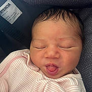 Alaia is registered to the contest to win money with this photo: newborn, baby, infant, sleeping, face, mouth, clothing, pink, striped, seat, car_seat, cushion, closeup, skin, hair, child, safety_tag, indoors, portrait, peaceful