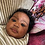 Tylee joined the competition — help win amazing prizes! baby, infant, closeup, face, curly_hair, striped_clothing, couch, cushion, indoor, portrait, child, young, expression, resting, soft_lighting, human, person, cute, looking, skin