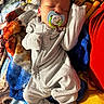 baby, newborn, sleeping, pacifier, onesie, striped_clothing, blanket, soft_texture, cozy, infant, peaceful, cute, child, resting, indoors, closeup, portrait, baby_clothes, comfort, toddler
