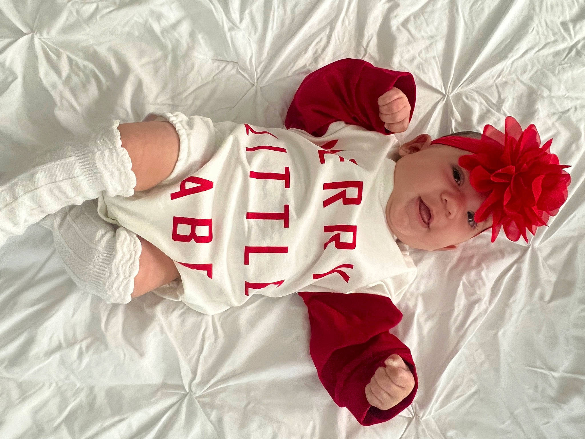 Ariella is registered to the contest to win money with this photo: arm, baby, baby_toddler_clothing, carmine, child, comfort, dress, hand, happy, hat, head, headwear, human_body, human_leg, knee, pattern, person, skin, sleeve, sock