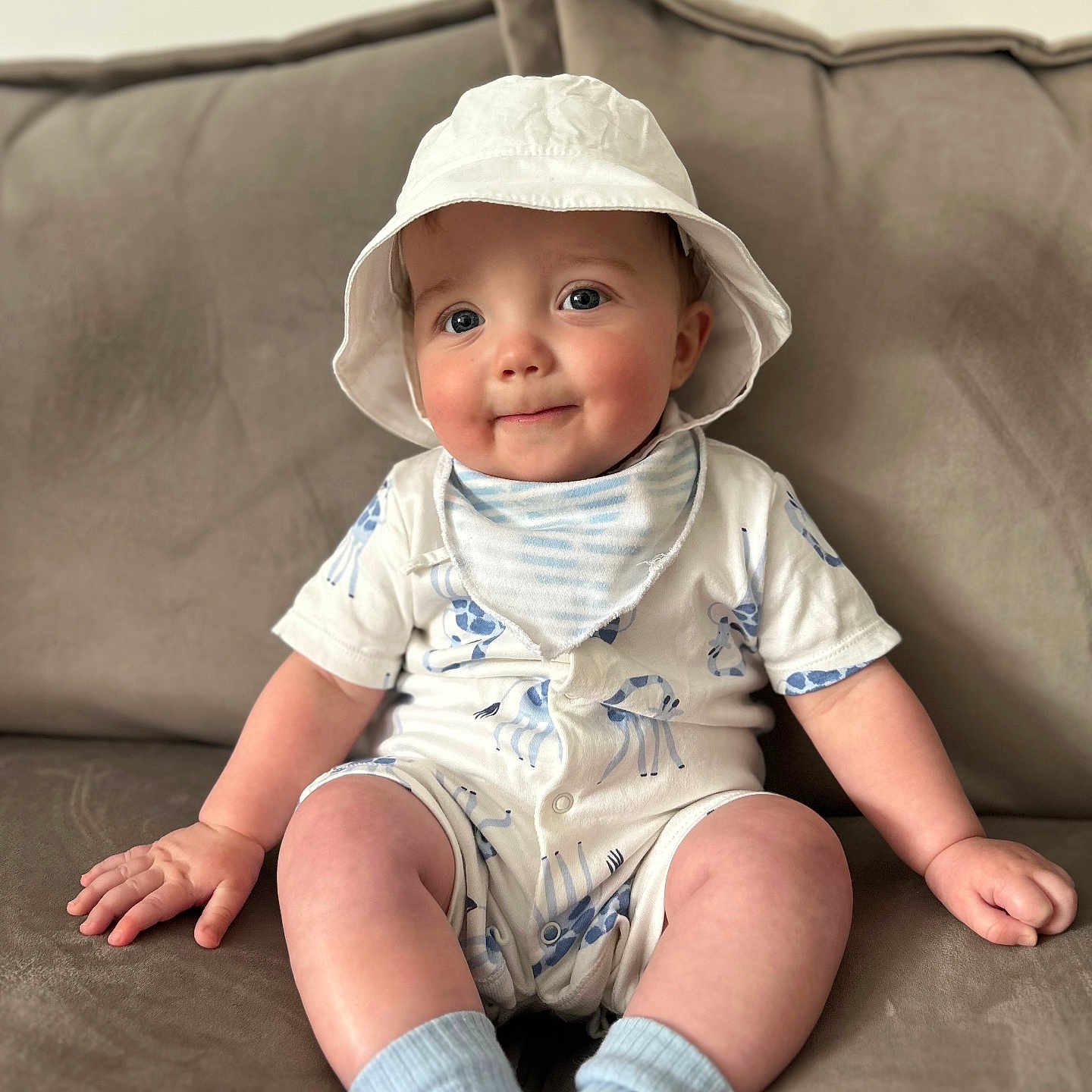 Harlow is registered to the contest to win money with this photo: baby, beachwear, cap, clothing, couch, face, furniture, happy, hat, head, hosiery, pants, person, photography, portrait, sitting, sleeve, smile, sock, sunhat