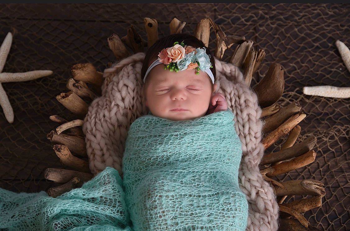 Alexandra is registered to the contest to win money with this photo: baby, baby_toddler_clothing, beanie, cap, child, crochet, eye, fashion_accessory, fur, hair_accessory, headgear, headpiece, headwear, knit_cap, linens, neck, person, sitting, toddler, wood