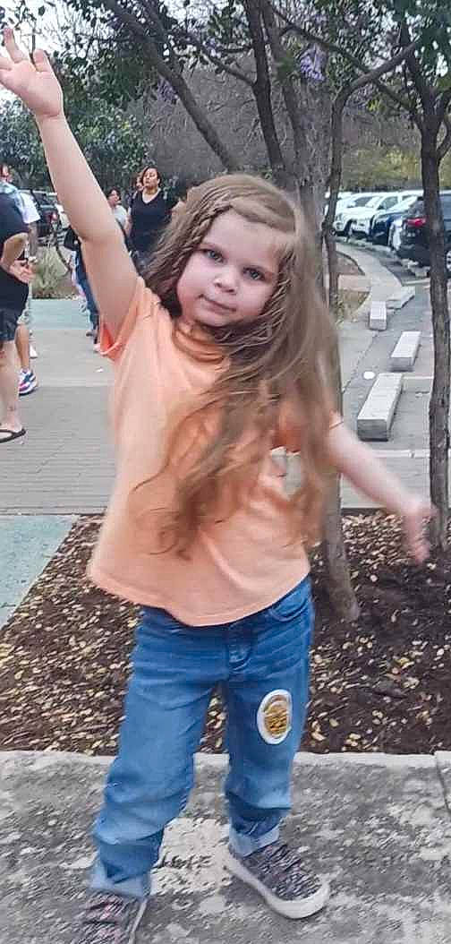 Adalyn is registered to the contest to win money with this photo: asphalt, cool, denim, event, fun, fur, gesture, grass, hairstyle, happy, leg, long_hair, person, public_event, recreation, shorts, t_shirt, toddler, tree, trunk