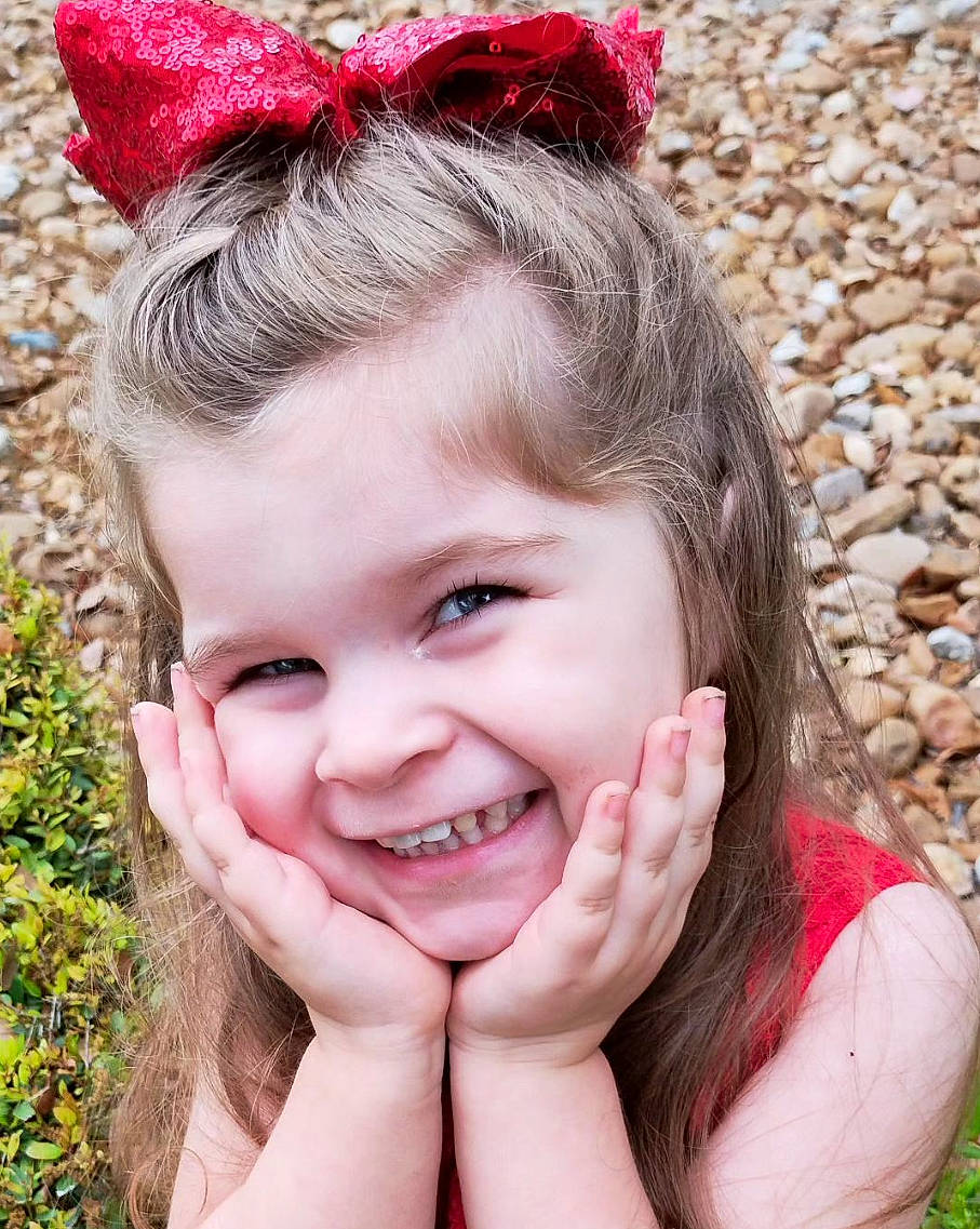 Adalyn is registered to the contest to win money with this photo: child, eye, face, fun, gesture, grass, hair, hand, happy, head, human, joy, lip, organ, people_in_nature, person, photograph, pink, plant, skin