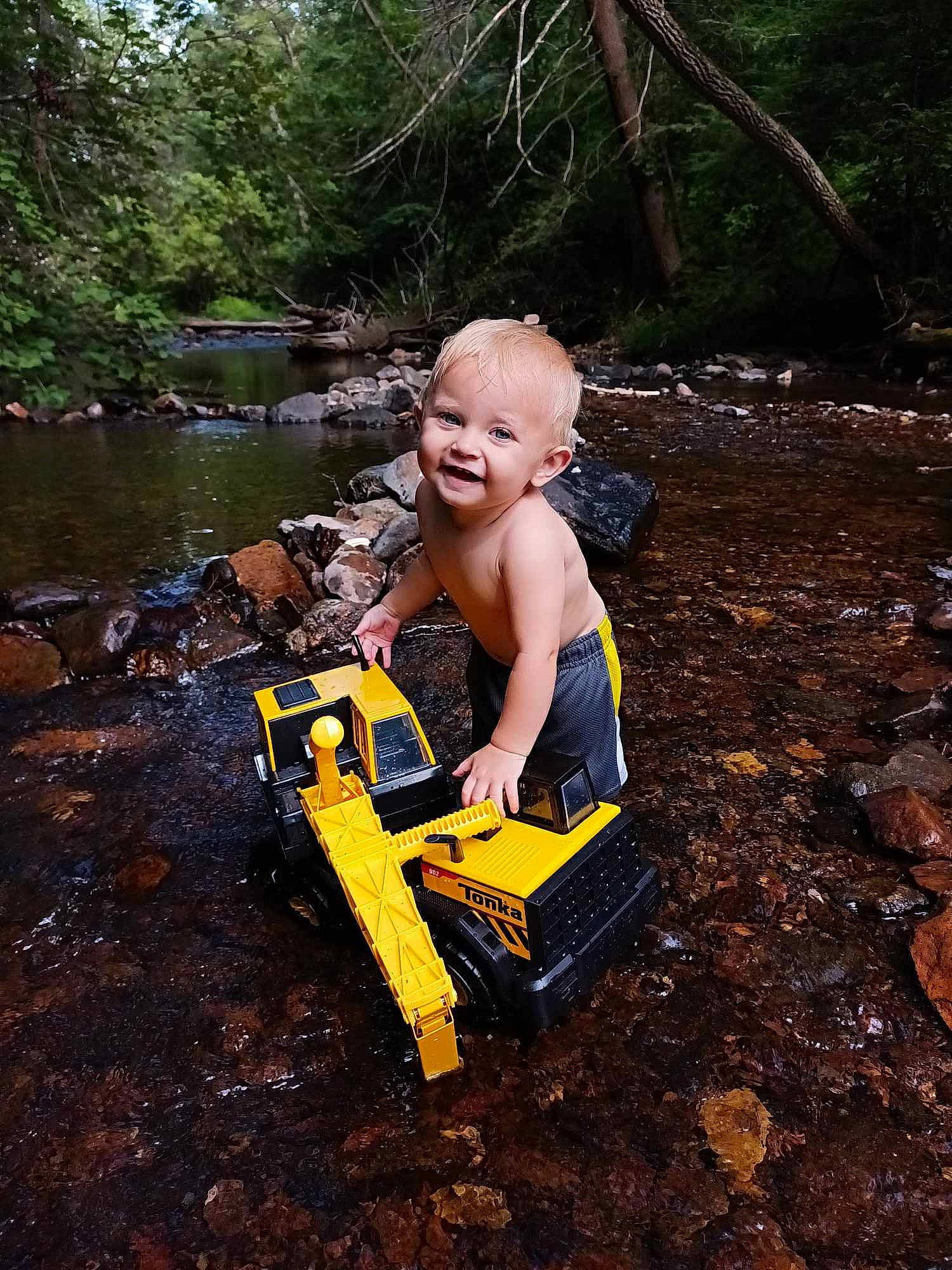 Jack joined the competition — help win amazing prizes! forest, fun, grass, human_body, jungle, landscape, leisure, musical_instrument, outdoor_furniture, people_in_nature, person, plant, recreation, sitting, smile, soil, stream, toddler, tree, water