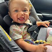 Lilyyana joined the competition — help win amazing prizes! baby, child, car_seat, smiling, face, blue_eyes, curly_hair, bow, toy, bottle, seatbelt, clothing, infant, hand, cute, portrait, inside_car, happiness, safety, person