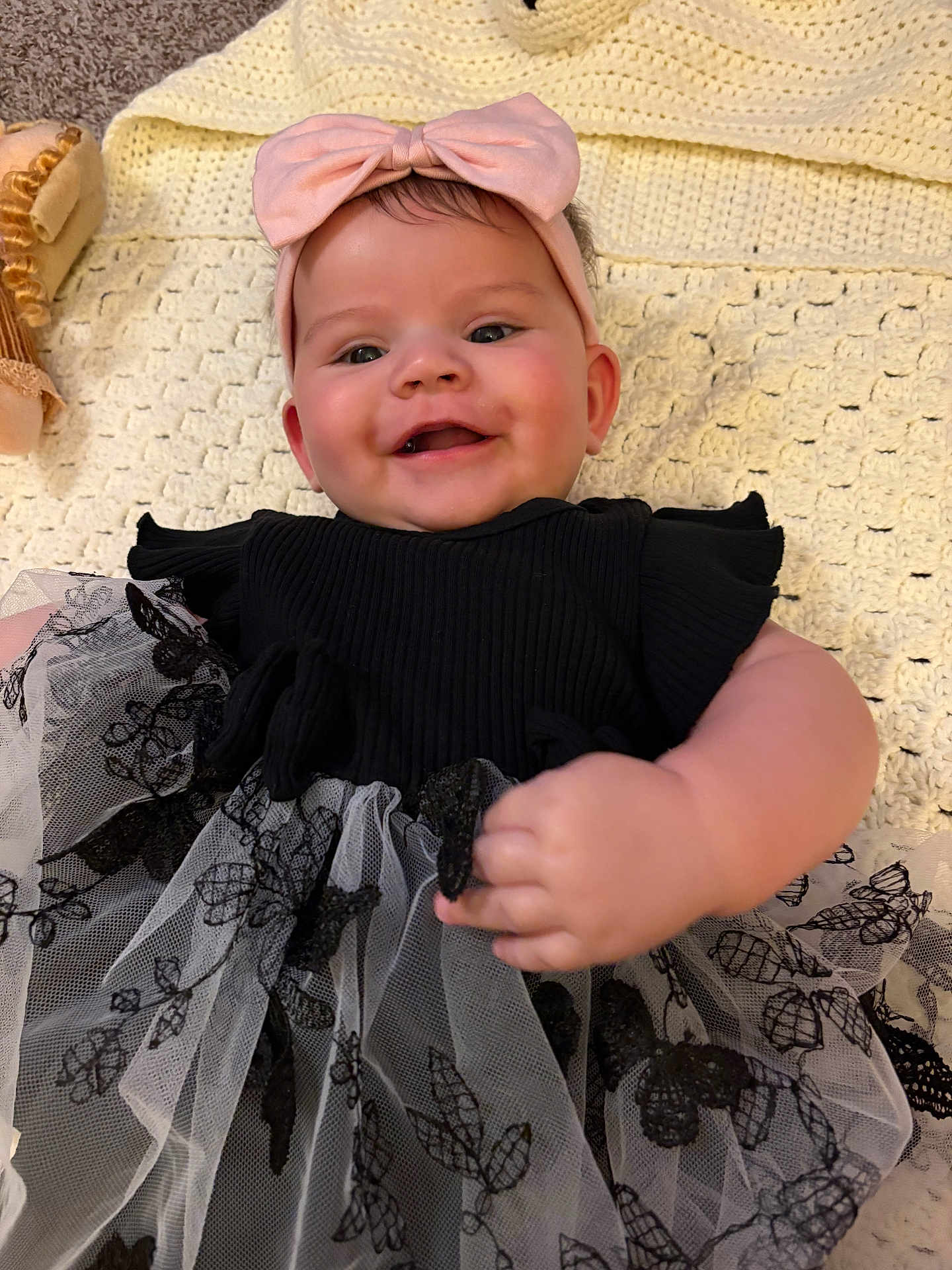 Hope joined the competition — help win amazing prizes! baby, smiling, headband, bow, dress, black_dress, lace, blanket, crocheted_blanket, hand, face, happy, infant, person, portrait, cute, indoor, soft_lighting, child, apparel