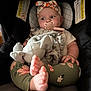 baby, infant, car_seat, pacifier, headband, blanket, plush_toy, legs, feet, floral_leggings, child, cute, comfort, indoor, seat, soft_toy, clothing, baby_accessory, relaxing, portrait