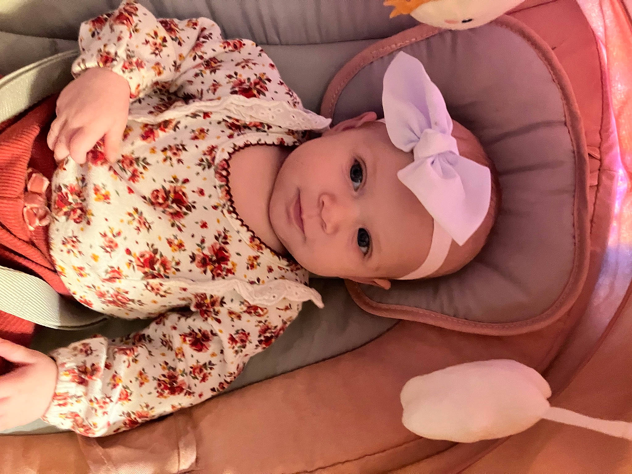 Lennon is registered to the contest to win money with this photo: baby, baby_products, baby_toddler_clothing, child, comfort, doll, eyelash, fashion_accessory, hat, headwear, pattern, peach, person, pink, room, sitting, skin, sleeve, smile, textile