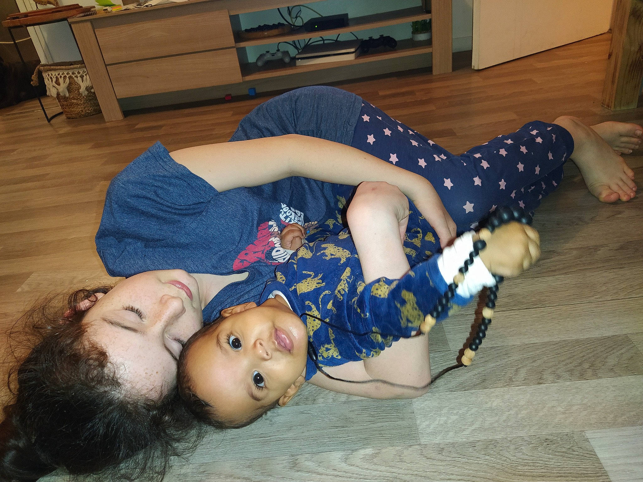 Azaïah participe au concours pour gagner de l'argent avec cette photo : child, comfort, elbow, flooring, fun, fur, hardwood, houseplant, human_leg, joint, knee, lap, pattern, person, picture_frame, room, sitting, sock, textile, thigh