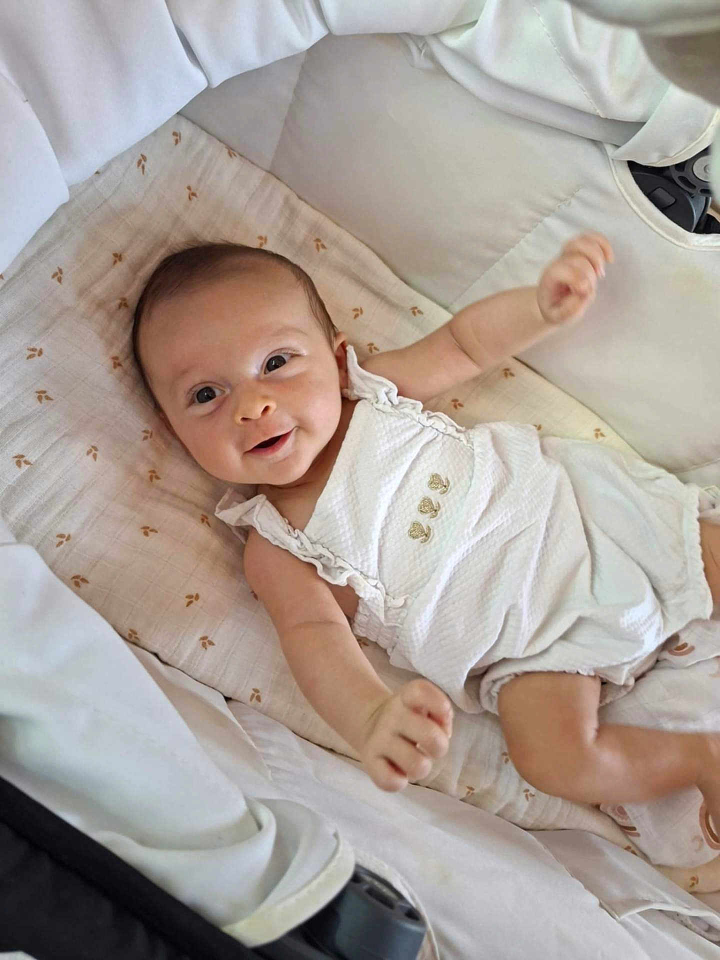 Roxane a rejoint le concours — aidez-le/la à gagner de superbes lots ! baby, infant, smiling, happy, blanket, cushion, playpen, clothing, white_outfit, child, cute, lying_down, indoors, face, head, skin, arm, hand, expression, newborn