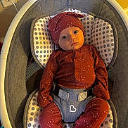 Nora is registered to the contest to win money with this photo: baby, infant, child, baby_rocker, cushion, polka_dot, hat, onesie, clothing, indoor, seat, face, person, baby_girl, baby_boy, cute, comfort, resting, looking, warm_light