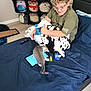 Speedy joined the competition — help win amazing prizes! child, kitten, bed, blanket, tablet, plush_toys, glasses, curly_hair, smiling, indoor, blue_bedspread, remote_control, wooden_floor, shelf, toy_collection, casual_clothing, playful, motion_blur, cozy, young_person