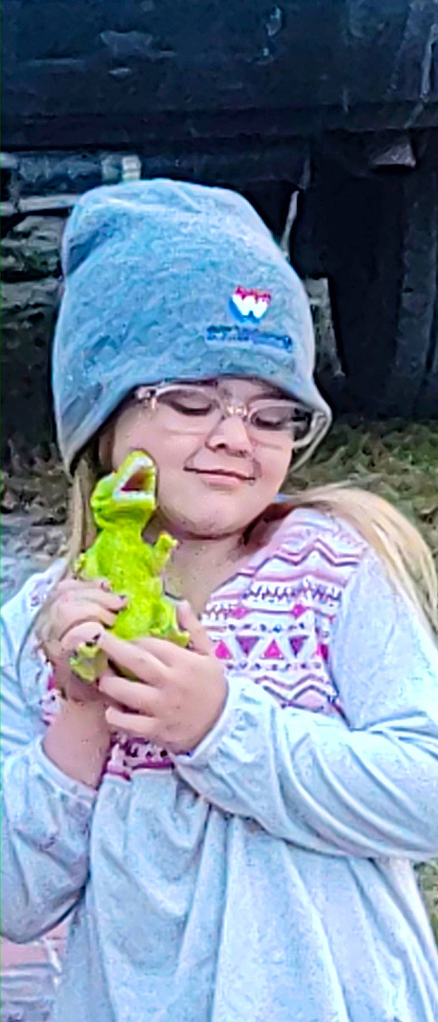 Kyleigh is registered to the contest to win money with this photo: amphibian, automotive_tire, baseball_cap, cap, child, eyewear, frog, fun, glasses, grass, happy, hat, headwear, joy, person, plant, smile, sunglasses, tire, toddler
