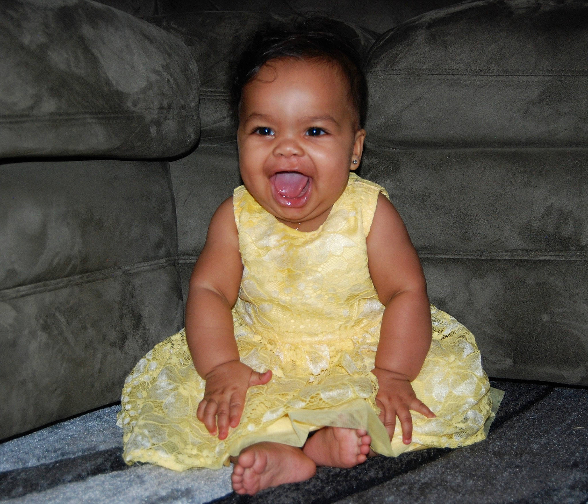 Evalynn is registered to the contest to win money with this photo: baby, cheek, child, dress, eye, face, facial_expression, finger, hand, head, mouth, person, sitting, skin, smile, toddler, yellow