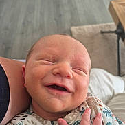 Gabriel participe au concours pour gagner de l'argent avec cette photo : newborn, baby, smiling, face, hand, onesie, patterned_clothing, sleeping, infant, skin, person, closeup, cozy, peaceful, indoors, floor, carpet, human, portrait, cute