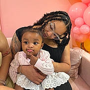 Elyana is registered to the contest to win money with this photo: child, woman, baby, braids, glasses, pink_sweater, white_skirt, balloons, pink_wall, sofa, couch, tattoo, bracelet, happy, indoor, celebration, family, cute, portrait, affection