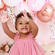Elyana is registered to the contest to win money with this photo: toddler, child, smiling, pink_dress, balloons, flowers, happy, portrait, celebration, curly_hair, earrings, flower_crown, indoor, cute, baby, cheerful, hands_up, festive, decorations, photo_shoot