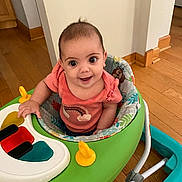 Gracelynn is registered to the contest to win money with this photo: baby, chair, clothing, face, furniture, happy, head, number, person, photography, play, playarea, portrait, sitting, sleeve, smile, symbol, t_shirt, table, text