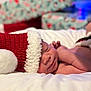 Blaise is registered to the contest to win money with this photo: baby, newborn, sleeping, santa_hat, red_hat, white_fur, blanket, holiday, christmas, festive, soft, cozy, infant, face, skin, cute, resting, child, indoors, closeup