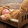 baby, sleeping, costume, bear, wooden_bed, fur_blanket, cozy, cute, infant, child, indoors, portrait, soft_texture, brown, warm, resting, peaceful, hat, hand, footwear