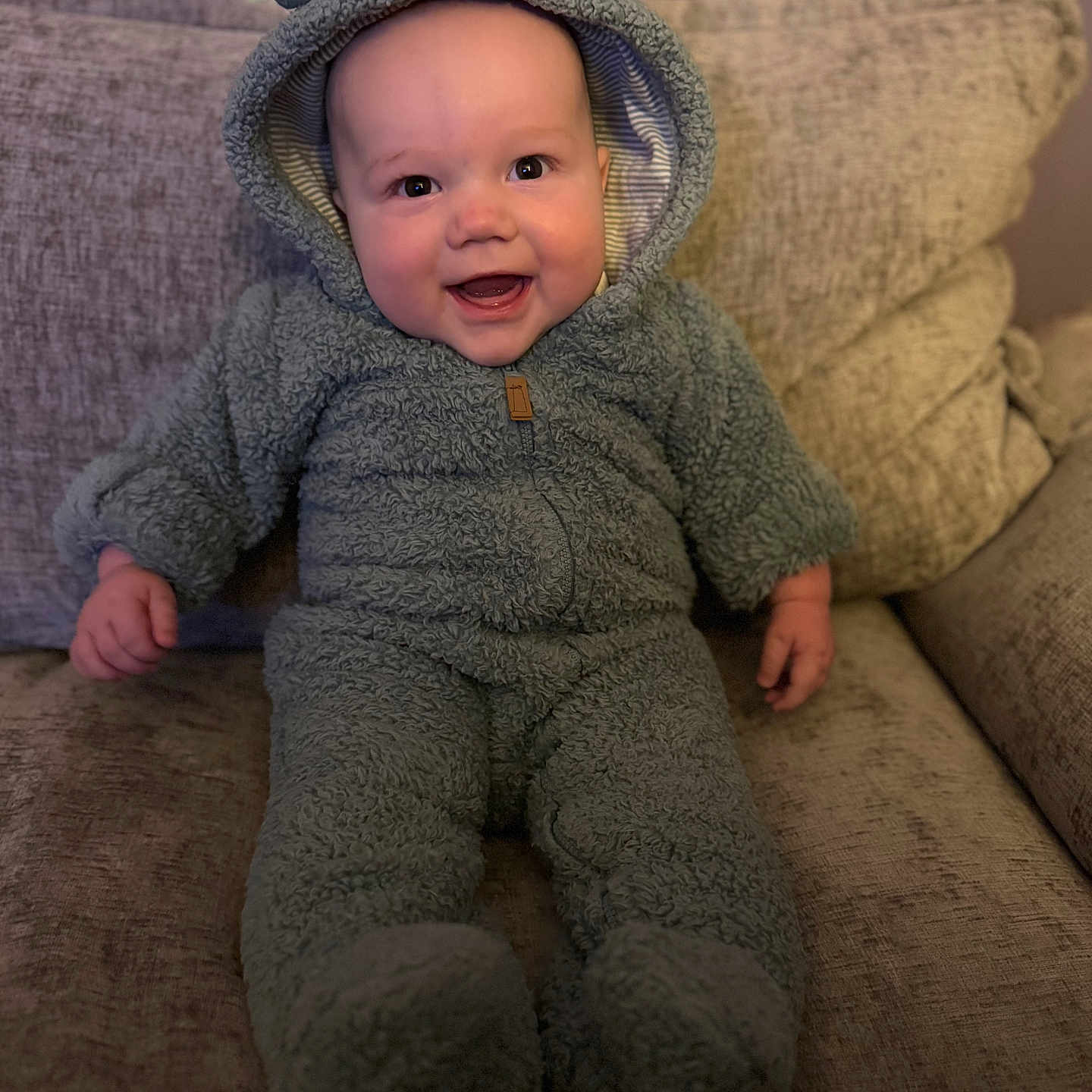 Camden joined the competition — help win amazing prizes! baby, bodypart, bonnet, cap, clothing, couch, face, furniture, happy, hat, head, hood, hoodie, knitwear, person, photography, portrait, smile, sweater, sweatshirt