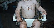 Tommus is registered to the contest to win money with this photo: baby, barefoot, chair, child, chocolate, clothing, face, flash_photography, food, funny, happy, high_chair, home, indoors, messy, playful, portrait, seated, smiling, toddler